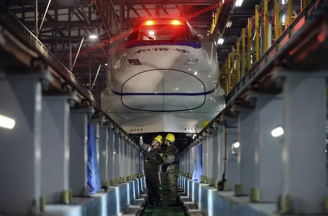 Mechanics examine a bullet train at a high speed railway maintenance station, to prepare for the annual mass migration ahead of the Chinese lunar new year, in Nanjing, Jiangsu province Monday, February 02, 2015. (Photo by Reuters/China Daily)