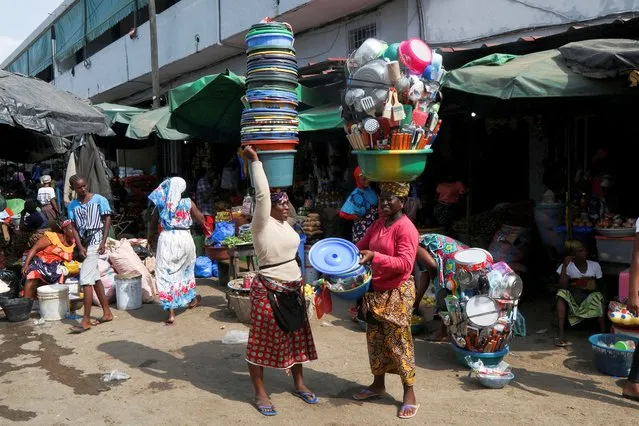 Vendors carry their goods at a market in the popular district of Adjame in Abidjan, Ivory Coast, March 1, 2022. (Photo by Luc Gnago/Reuters)
