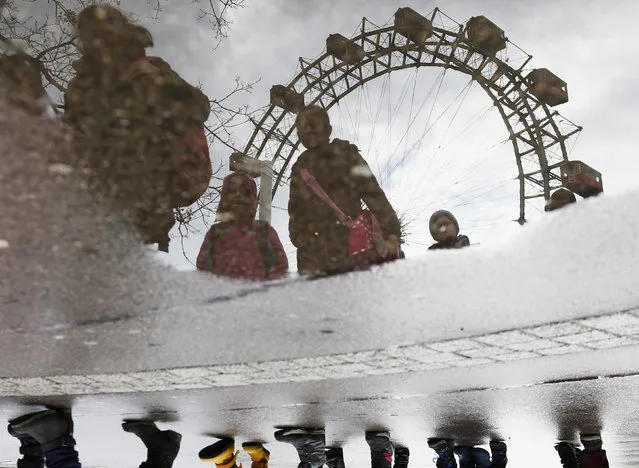 Riesenrad (giant wheel) landmark and a group of children are reflected in a puddle at Wurstelprater, the world's oldest amusement park, in Vienna, Austria, March 15, 2016. (Photo by Heinz-Peter Bader/Reuters)