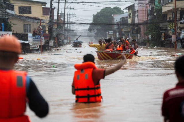 Rescuers assist residents on a boat along a flooded road following heavy rains brought by Typhoon Gaemi, in Marikina City, Metro Manila, Philippines, on July 24, 2024. (Photo by Lisa Marie David/Reuters)