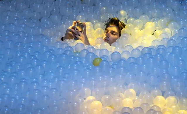 A participant takes a break in a plastic ball swimming pool at the C2MTL business conference, Wednesday, May 25, 2016 in Montreal. (Photo by Paul Chiasson/The Canadian Press via AP Photo)