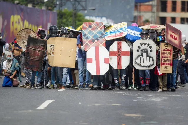 People participate in an opposition demonstration in Caracas, Venezuela, 22 May 2017. Doctors and workers in the health sector in Venezuela rallied in favor of and against the process of a new Constituent Assembly, on day 52 of the mobilizations that shakes the country and that has left at least 50 dead, according to figures of the Authorities and the opposition. (Photo by Miguel Gutiérrez/EPA)