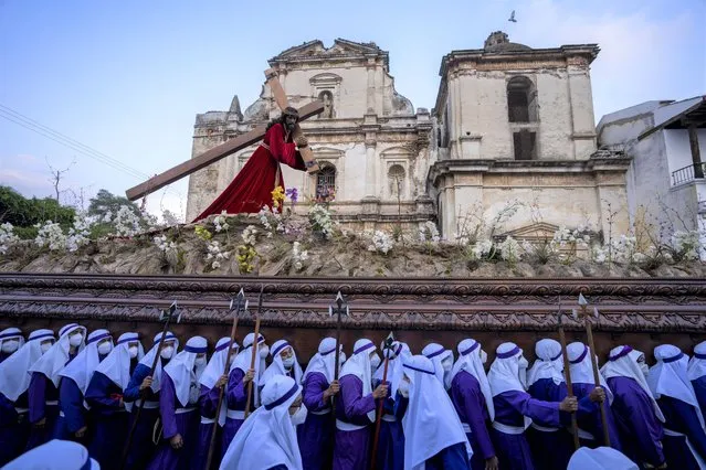 Worshipers carry a religious float with a image of Jesus Christ during a Good Friday procession of La Merced church in Antigua, Guatemala, Friday, April 15, 2022. Around the world, Christians are coming together in observance of Good Friday, which they believe was the day Jesus was crucified. (Photo by Moises Castillo/AP Photo)