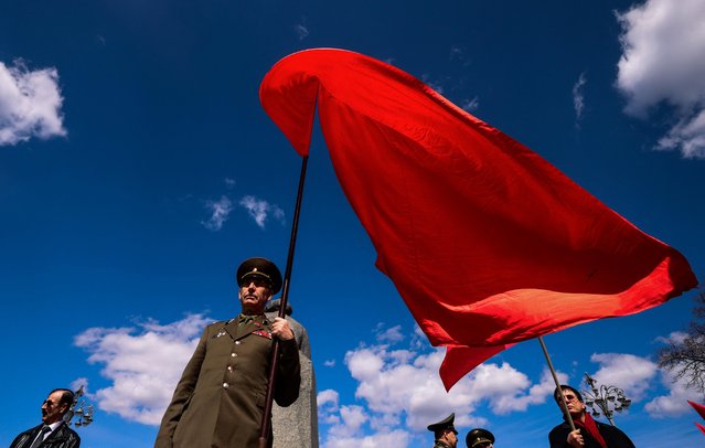 A supporter of Russia's Communist party holds a flag during a May Day rally in Moscow, Russia on May 1, 2022. (Photo by Maxim Shemetov/Reuters)