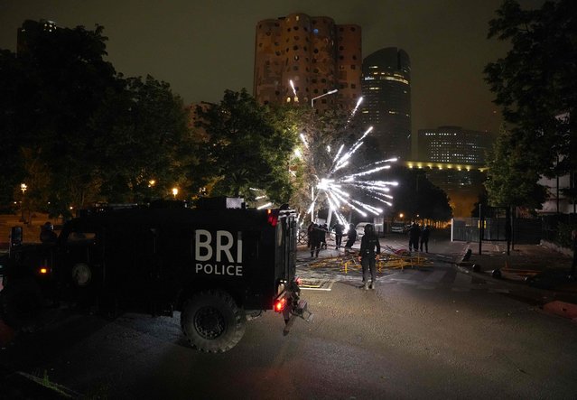 Police stand by as material explodes in the Cite Pablo Picasso area of Nanterre, north-west of Paris early June 30, 2023, as protests continue across France in the aftermath of the killing by a policeman of a teenage driver in the Parisian suburb of Nanterre. Violent protests broke out in France in the early hours of June 29, as anger grows over the police killing of a teenager, with security forces arresting 150 people in the chaos that saw balaclava-clad protesters burning cars and setting off fireworks. Nahel M., 17, was shot in the chest at point-blank range in Nanterre in the morning of June 27, 2023, in an incident that has reignited debate in France about police tactics long criticised by rights groups over the treatment of people in low-income suburbs, particularly ethnic minorities. (Photo by Zakaria Abdelkafi/AFP Photo)