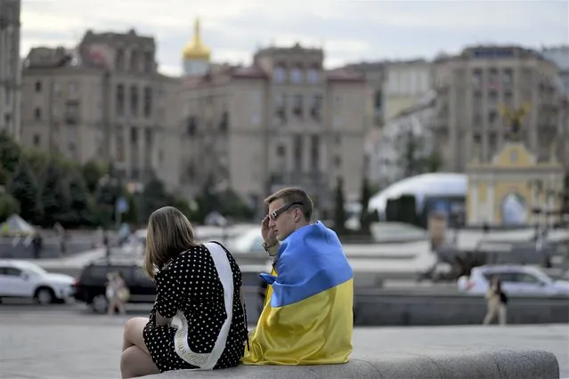 A couple talk in downtown Kyiv, Ukraine, Wednesday, May 25, 2022. (Photo by Natacha Pisarenko/AP Photo)