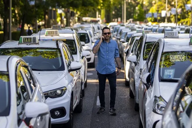Taxi drivers block an avenue during a taxi driver protest in downtown Madrid, Spain, Wednesday, June 1, 2022. Hundreds of taxi drivers protested in the streets of Madrid on Wednesday against what they claim is unfair competition from ride-hailing services. (Photo by Manu Fernandez/AP Photo)