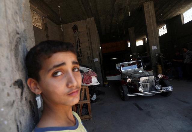 The son of Palestinian Munir Shindi, 36, stands near a replica of a 1927 Mercedes Gazelle that his father built from scratch, in Gaza City June 19, 2016. (Photo by Mohammed Salem/Reuters)