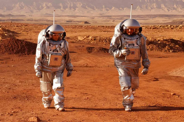 A couple of astronauts from a team from Europe and Israel walk in spacesuits during a training mission for planet Mars at a site that simulates an off-site station at the Ramon Crater in Mitzpe Ramon in Israel's southern Negev desert on October 10, 2021. Six astronauts from Portugal, Spain, Germany, the Netherlands, Austria, and Israel will be cut off from the world for a month, from October 4-31, only able leave their habitat in spacesuits as if they were on Mars. Their mission, the AMADEE-20 Mars simulation, will be carried out in a Martian terrestrial analog and directed by a dedicated Mission Support Center in Austria, to conduct experiments ahead of future human and robotic Mars exploration missions. (Photo by Jack Guez/AFP Photo)