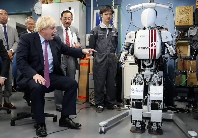 Britain's Foreign Secretary Boris Johnson (L) looks at the bipedal humanoid robot Wabian2 at the Research Institute for Science and Engineering at Waseda University's Kikuicho campus in Tokyo on July 20, 2017. Johnson is on a three-day visit to Japan. (Photo by Eugene Hoshiko/AFP Photo)