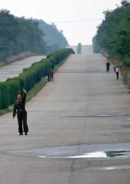 Yes, in North Korea, you can bike without danger on highways. Lot of peple try to stop cars but they need to wait for hours... When i asked to stop to take them as the tourist bus i had was empty, my guide refused, saying it was totally impossible to do this. (Photo by Eric Lafforgue/Exclusivepix Media)