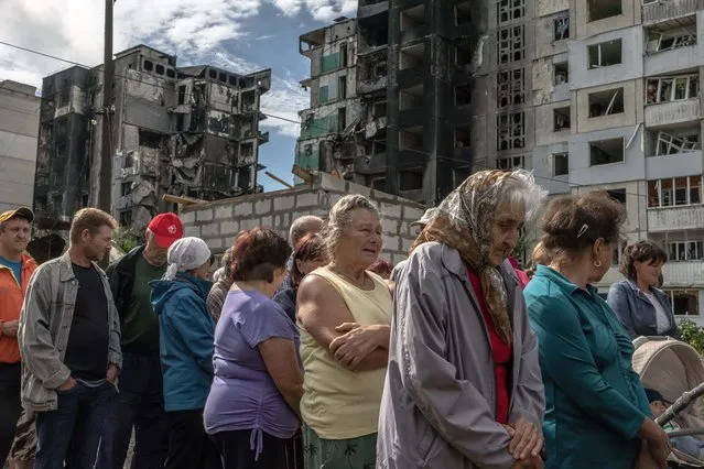 Local residents wait to receive humanitarian aid in front of a residential building that was damaged during the Russian attack, in Borodyanka, Kyiv region, Ukraine, 21 June 2022. Towns and villages in the northern part of the Kyiv region became battlefields, heavily shelled, causing death and damage when Russian troops tried to reach the Ukrainian capital Kyiv in February and March 2022. On 24 February Russian troops entered Ukrainian territory starting a conflict that has provoked destruction and a humanitarian crisis. (Photo by Roman Pilipey/EPA/EFE)