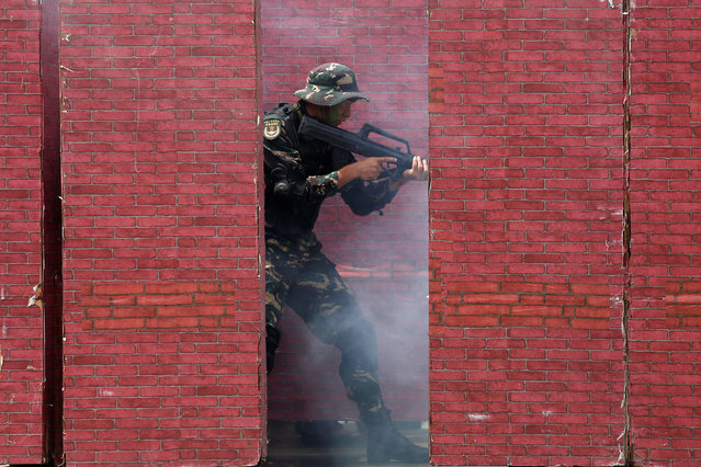 A People's Liberation Army soldier storms a structure during an anti-terrorist demonstration at a naval base, celebrating the 19th anniversary of Hong Kong's handover to Chinese sovereignty from British rule, in Hong Kong July 1, 2016. (Photo by Bobby Yip/Reuters)