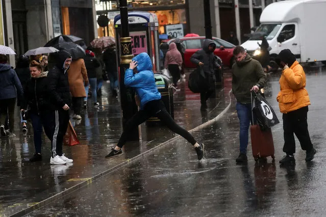 Pedestrians try to avoid a puddle as they walk down Oxford Street during Storm Dennis in London, Britain on February 16, 2020. (Photo by Simon Dawson/Reuters)