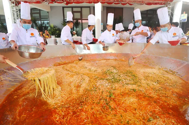 Chefs prepare a big bowl of laoyou noodles outside a restaurant in Nanning, Guangxi Autonomous Region, China, August 12, 2017. (Photo by Reuters/China Stringer Network)
