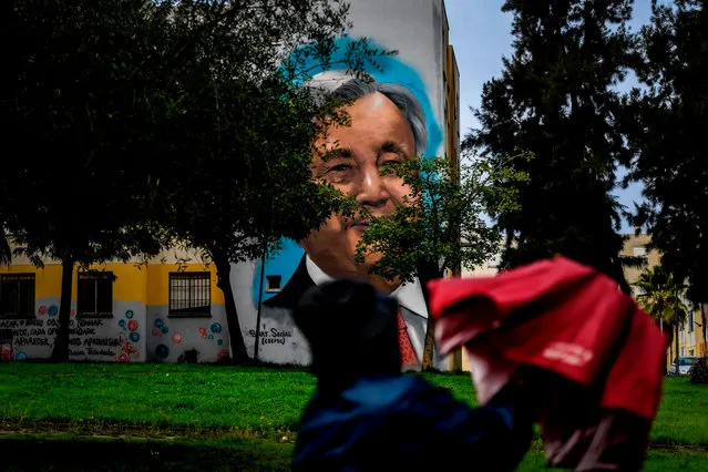 Visitors watch a mural depicting United Nations Secretary General Antonio Guterres by Portuguese artist Sergio Odeith during a guided visit to Quinta do Mocho neighbourhood in Sacavem, outskirts of Lisbon, on November 11, 2019. (Photo by Patricia De Melo Moreira/AFP Photo)