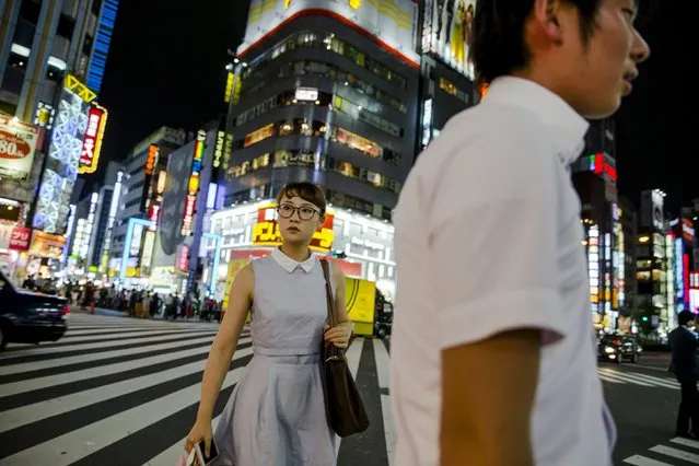 People cross a junction in Shinjuku's nightlife district of Kabukicho in Tokyo, August 27, 2015. (Photo by Thomas Peter/Reuters)