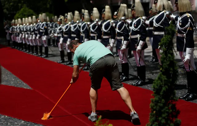 A man sweeps the red carpet as the honor guard awaits the arrival of French President Francois Hollande at the Belem Palace in Lisbon, Portugal, July 19, 2016. (Photo by Rafael Marchante/Reuters)