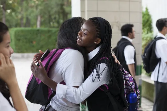 Caroline Mogomela hugs Yesenia Villada on her first day of school at St. Patrick Secondary School in Toronto, September 2, 2014. Mogomela came from Botswana in July and will be starting Grade 9. She participated in the NOW Program (Newcomer Orientation Week) that helps newcomer students like her get to know the Ontario education system and meet other newcomer students. Villada immigrated from Colombia when she was 15 and is was  a peer leader in the NOW program. (Photo by Marta Iwanek/Toronto Star via Getty Images)
