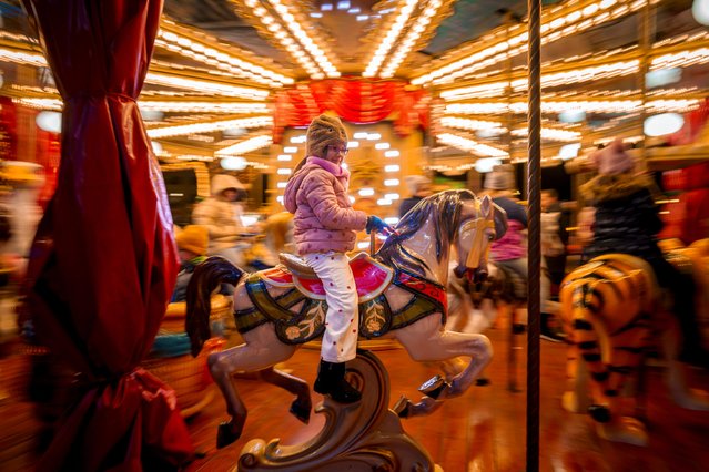 A child rides on a merry go round at Christmas fair in Bucharest, Romania, Saturday, December 14, 2024. (Photo by Vadim Ghirda/AP Photo)