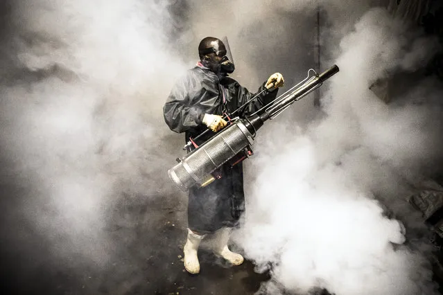 A member of a privately-funded NGO working with county officials wearing protective gear fumigates and disinfects on April 15, 2020, during the dusk-to-dawn curfew imposed by the Kenyan Government, the streets and the stalls at Parklands City Park Market in Nairobi to help curb the spread of the COVID-19 coronavirus. With a current official number of 225 confirmed coronavirus cases, Kenya has so far cordoned off the capital and parts of its coastline and imposed a curfew and other social distancing measures as part of the country efforts to control the spread of the virus. (Photo by Luis Tato/AFP Photo)