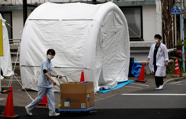 Medical workers walk by tents set up to test for the coronavirus disease (COVID-19) infection at Kawakita General Hospital in Tokyo, Japan, April 17, 2020. (Photo by Kim Kyung-Hoon/Reuters)