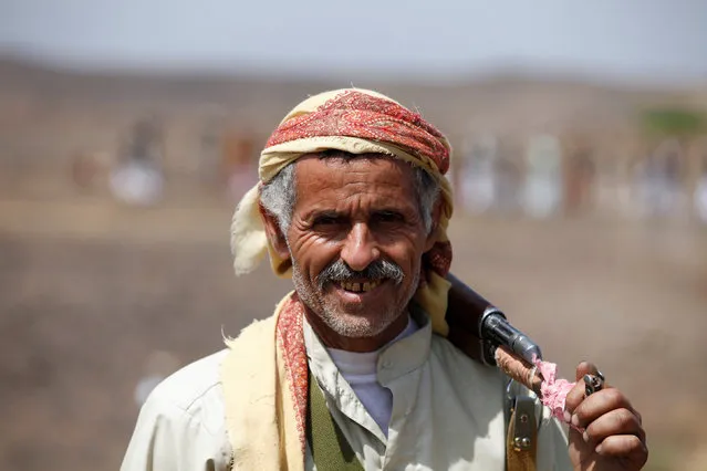 A tribesman carries his rifle as he attends a pro-Houthi tribal gathering in a rural area near Sanaa, Yemen July 21, 2016. (Photo by Khaled Abdullah/Reuters)