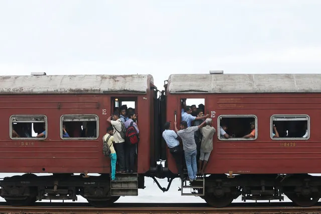 Commuters travel to work by train in Colombo, Sri Lanka on June 13, 2017. (Photo by Dinuka Liyanawatte/Reuters)