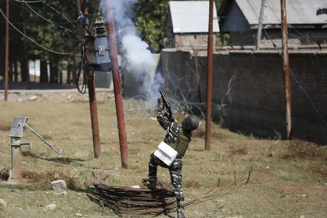 A security person fires tear gas to disperse Kashmiri villagers who clashed with government forces in Hajin, 38 kilometers (24 miles) north of Srinagar, Indian controlled Kashmir, Wednesday, October 11, 2017. Soldiers began an anti-militant operation by cordoning off northern Hajin town on a tip that rebels were hiding in the area. Two Indian air force commandos and two rebels were killed in the ensuing intense fighting. Street clashes erupted shortly after the fighting ended as hundreds of residents demanded an end to Indian rule in Kashmir. (Photo by Mukhtar Khan/AP Photo)