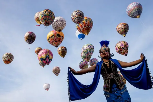 A Javanese dancer performs at the Java Balloon attraction on the sidelines of the Dieng Culture Festival at Kalianget Park on September 04, 2022 in Wonosobo, East Java, Indonesia. The Dieng Culture Festival is an annual event presenting a variety of Javanese traditional arts and culture, culminating with a hair trimming ritual ceremony of dreadlocked children, known as the Ruwatan Rambut Gimbal. (Photo by Robertus Pudyanto/Getty Images)