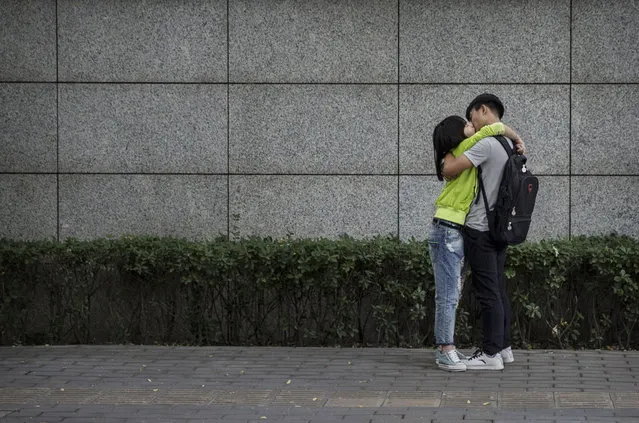 A young Chinese couple kiss in the street on September 16, 2014 in Beijing, China. (Photo by Kevin Frayer/Getty Images)