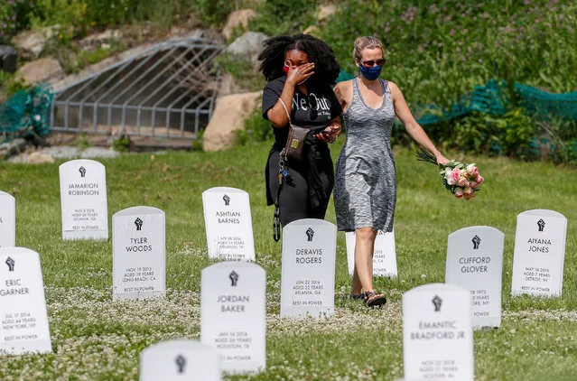 People walk among an art installation of headstones bearing the names of people killed by police near the site of the arrest of George Floyd, who died while in police custody, in Minneapolis, Minnesota, U.S. June 6, 2020. (Photo by Eric Miller/Reuters)