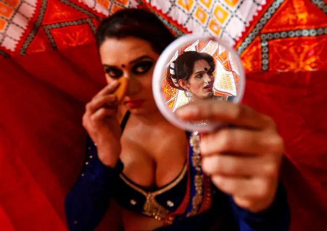 A eunuch applies make-up as another is reflected in a mirror before Raksha Bandhan festival celebrations in a red light area in Mumbai, India, August 17, 2016. (Photo by Danish Siddiqui/Reuters)