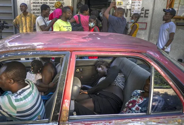 People inside a car suffering from cholera symptoms arrive at the door of a clinic run by Doctors Without Borders for treatment in Port-au-Prince, Haiti, Thursday, October 27, 2022. (Photo by Ramon Espinosa/AP Photo)