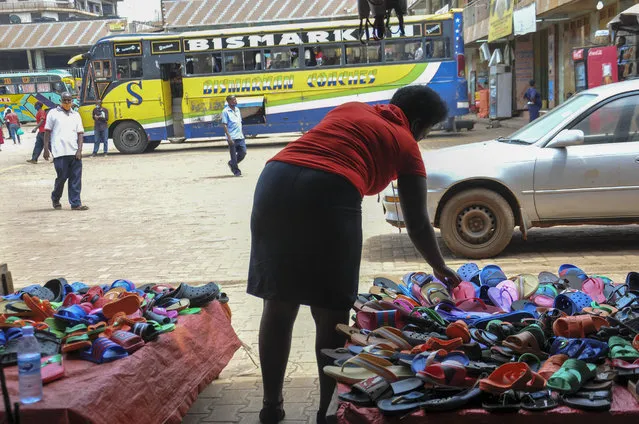 In this photo taken Saturday, June 20, 2020, Grace Twisimire, 25, adjust the display of plastic shoes for sale in her once-thriving shop in the capital Kampala, Uganda. The COVID-19 pandemic means that millions of women in Africa and other developing regions could lose years of success in contributing to household incomes, asserting their independence and expanding financial inclusion. (Photo by Ronald Kabuubi/AP Photo)