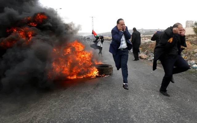 Palestinian lawyers run during clashes with Israeli troops at a protest against U.S. President Donald Trump's decision to recognise Jerusalem as the capital of Israel, near the Jewish settlement of Beit El, near the West Bank city of Ramallah December 13, 2017. (Photo by Mohamad Torokman/Reuters)
