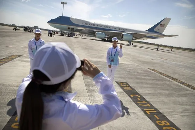 A Chinese volunteer poses for a photo in front of Air Force One after U.S. President Barack Obama arrived at the Hangzhou Xiaoshan International Airport, Saturday, September 3, 2016, in Hangzhou, China, to attend the G-20 summit. Obama is expected to meet with China's President Xi Jinping Saturday afternoon. (Photo by Mark Schiefelbein/AP Photo)