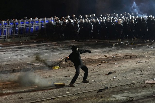 A protester throws a firework during a protest against the arrest of Istanbul's Mayor Ekrem Imamoglu, in Istanbul, Turkey, Saturday, March 22, 2025. (Photo by Khalil Hamra/AP Photo)
