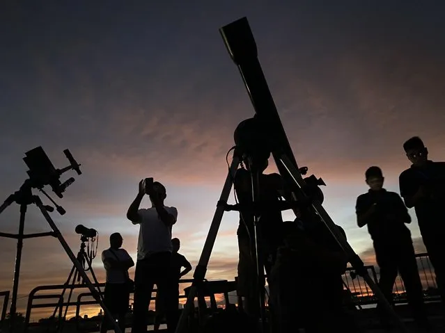 Filipino sky observers use a telescope to view the total lunar eclipse in Manila, Philippines, 08 November 2022. The next total lunar eclipse will not occur until March 2025. (Photo by Malasig/EPA/EFE/Rex Features/Shutterstock)