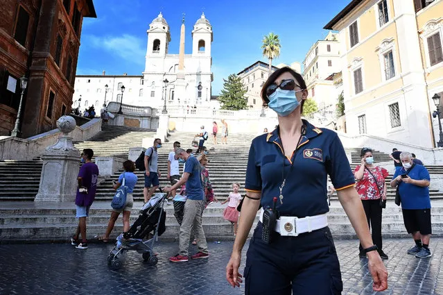 Italian Local Police officer patrols and checks with people wear protective facemasks at the Spanish Steps square, in Rome on August 17, 2020 as Italy declared mandatory to wear a protective facemask in all places where assemblies can be created to fight against the spread of the COVID-19 (novel coronavirus). (Photo by Alberto Pizzoli/AFP Photo)