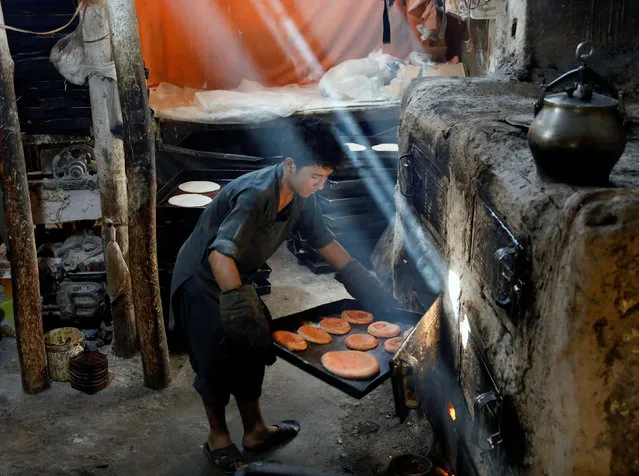 A man prepares cookies at a small traditional factory for the Eid al-Adha, amid the spread of the coronavirus disease (COVID-19), in Kabul, Afghanistan on July 29, 2020. (Photo by Mohammad Ismail/Reuters)