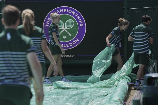Groundsmen cover a court ahead of the Wimbledon Championships at the All England Lawn Tennis and Croquet Club in London, Sunday, June 29, 2025. (Photo by Kin Cheung/AP Photo)