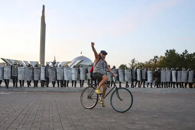 A protester rides a bicycle in front of a police during an opposition rally to protest the presidential inauguration in Minsk, Belarus, Wednesday, September 23, 2020. Belarus President Alexander Lukashenko has been sworn in to his sixth term in office at an inaugural ceremony that was not announced in advance amid weeks of huge protests saying the authoritarian leader's reelection was rigged. Hundreds took to the streets in several cities in the evening to protest the inauguration. (Photo by AP Photo/Stringer)