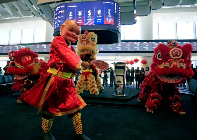 A dancer wearing a Chinese “Big Head Buddha” costume performs along with a Dragon dance during the opening bell ringing to mark the first trading day at the brand new Philippine Stock Exchange complex in Bonifacio Global city, the capital's newest financial district in Taguig city, metro Manila, Philippines February 19, 2018. (Photo by Romeo Ranoco/Reuters)