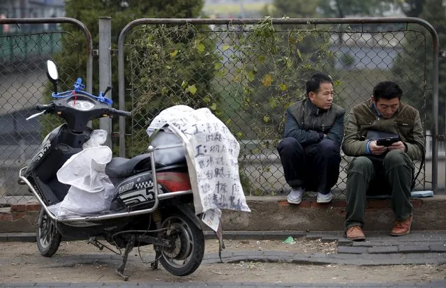 Migrant workers wait for jobs outside a construction materials market in Beijing, China, October 26, 2015. China's urban unemployment rate was 4.05 percent at the end of the third quarter, the social security ministry said on Tuesday, slightly higher than 4.04 percent at the end of the previous three-month period. (Photo by Jason Lee/Reuters)