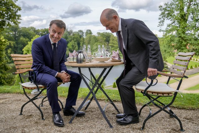 German Chancellor Olaf Scholz, right, and French President Emmanuel Macron sit at a table in the garden of the German government guest house in Meseberg, north of Berlin, Germany, Tuesday, May 28, 2024. (Photo by Ebrahim Noroozi/Pool via AP Photo)