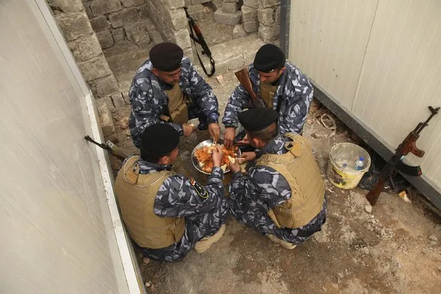 Sunni volunteers, who have joined the Iraqi army to fight against militants of the Islamic State, share a meal on the outskirts of Dohuk province December 8, 2014. (Photo by Ari Jalal/Reuters)