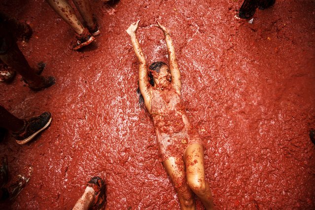 A woman reacts during the annual “Tomatina” tomato fight fiesta, in the village of Bunol near Valencia, Spain, Wednesday, August 27, 2025. (Photo by Alberto Saiz/AP Photo)