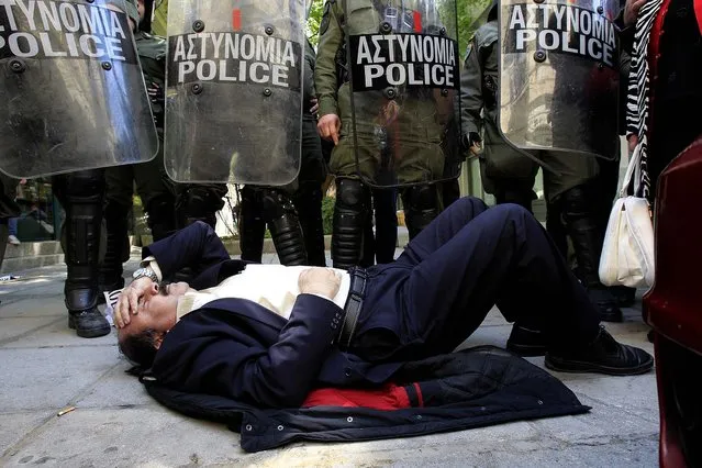Manolis Lampsidis, ex-president of Thessalonikis' lawyers union, lies in front of police in Thessaloniki, Greece, during a protest supporting two men arrested for allegedly taking part in an arson attack on a controversial gold mine operation in northern Greece, on April 20, 2013. (Photo by Nikolas Giakoumidis/Associated Press)