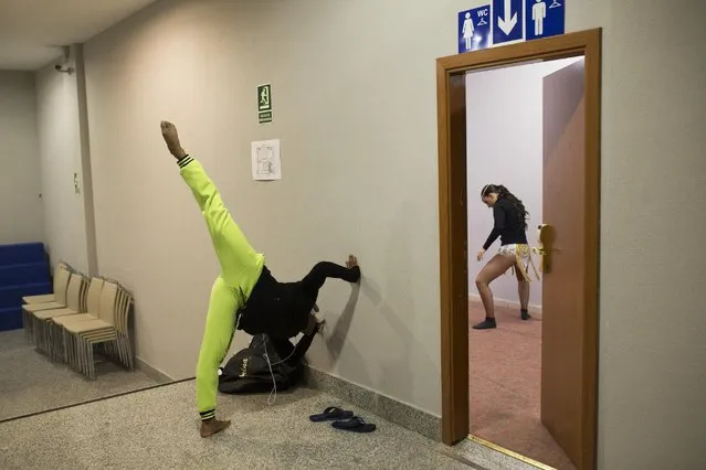 In this Friday, November 6, 2015 photo Venezuelan dancer Yeifren Mata, left, and Spanish Julia Fernandez stretch backstage before taking part in the World Salsa Master dance competition in Madrid. (Photo by Francisco Seco/AP Photo)